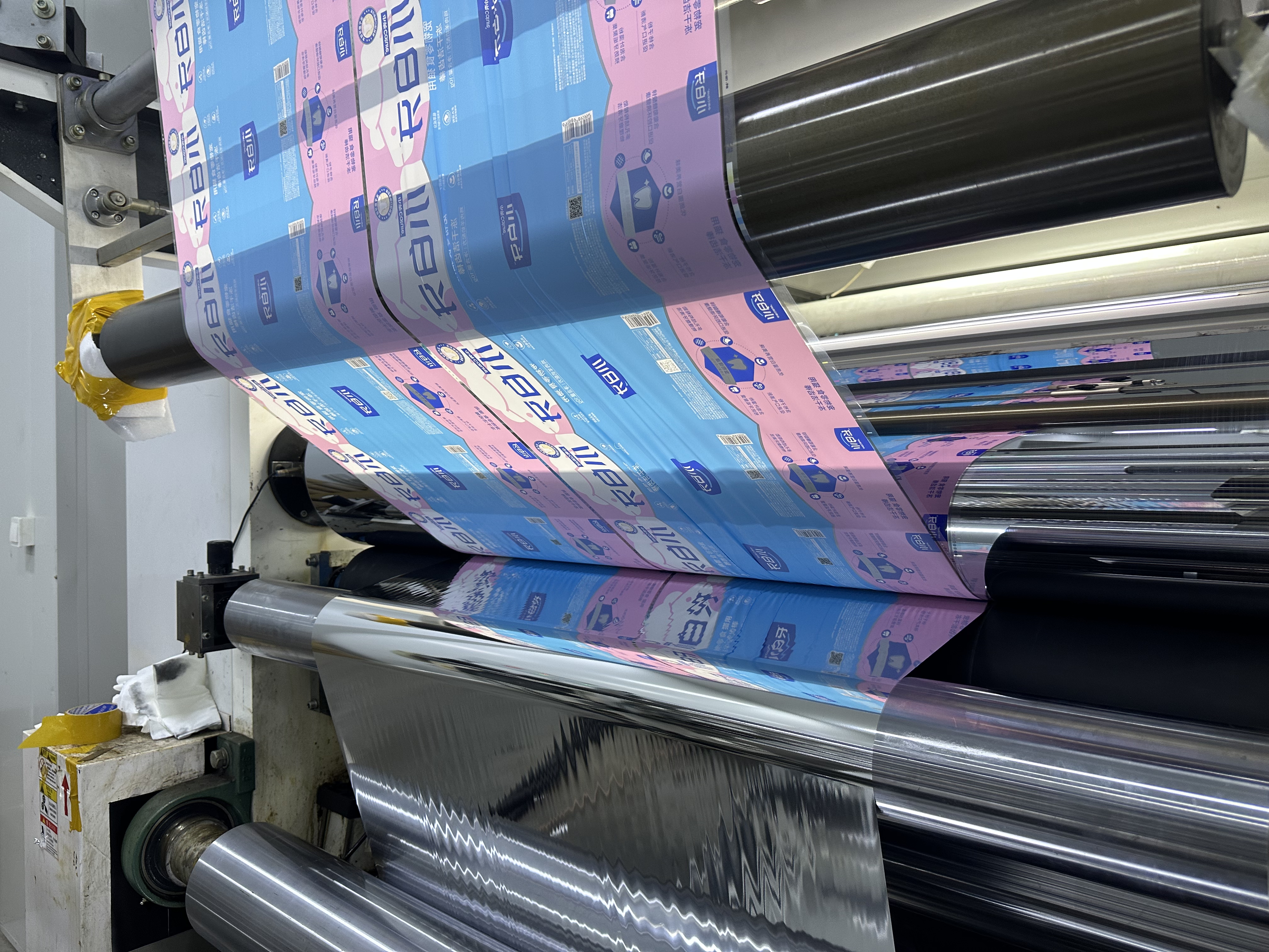 Printed flexible packaging film passing through a lamination machine